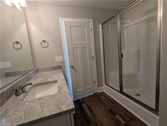 full bath with vanity, wood finished floors, and a shower stall