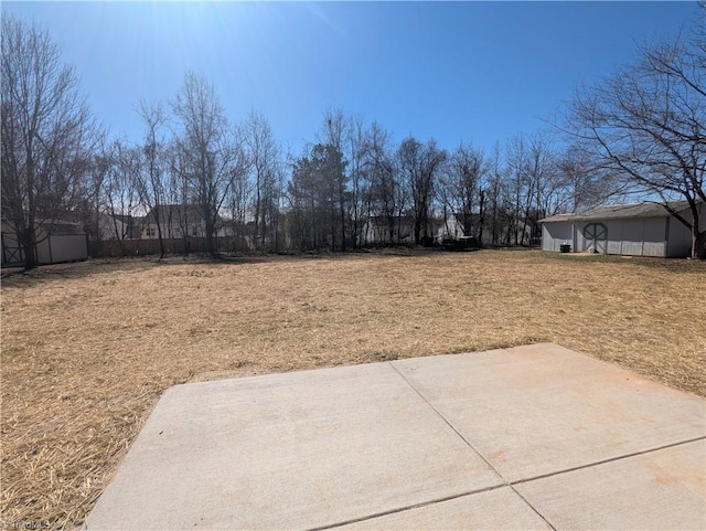 view of yard with a patio and an outbuilding