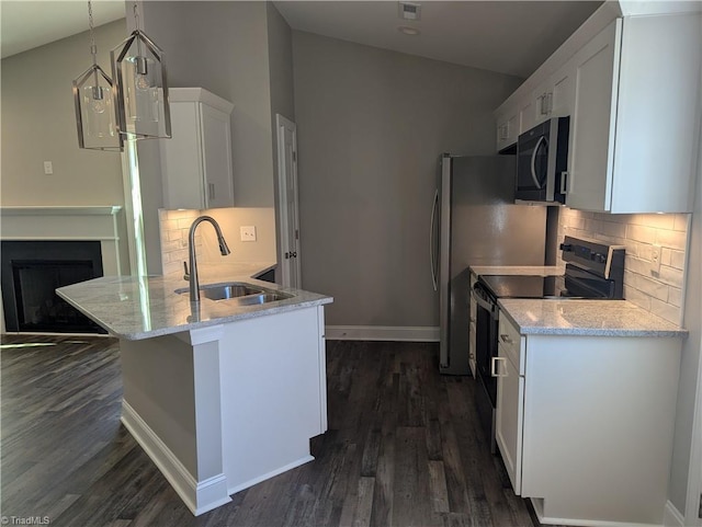 kitchen with baseboards, a peninsula, a sink, white cabinets, and appliances with stainless steel finishes