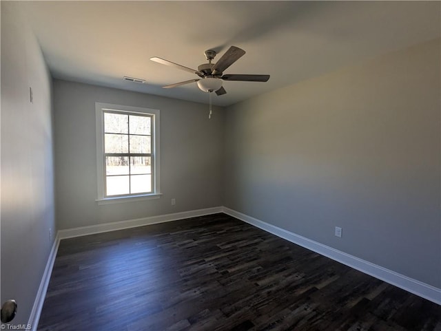 spare room with dark wood finished floors, baseboards, and visible vents