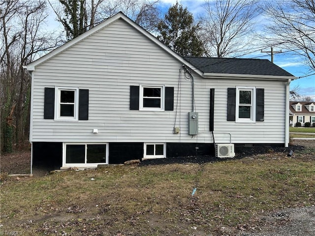 view of side of home featuring ac unit and a yard