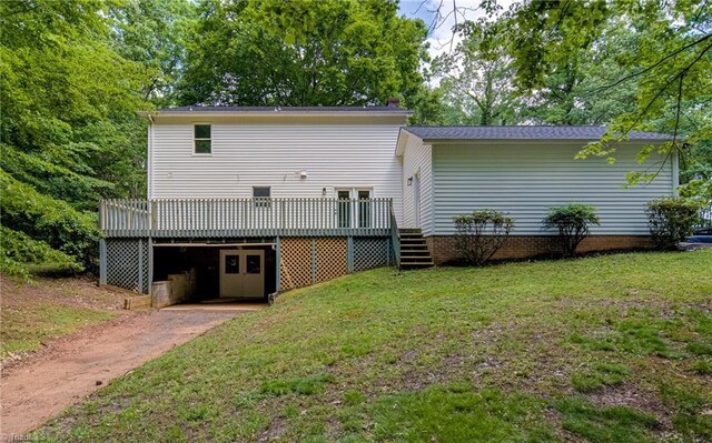 back of house featuring a wooden deck, a lawn, and stairway