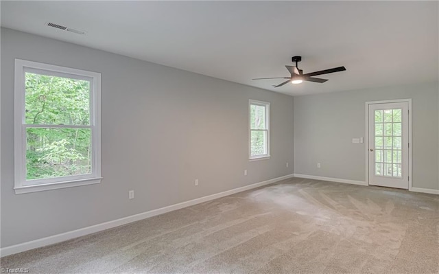 spare room with a ceiling fan, baseboards, and light carpet