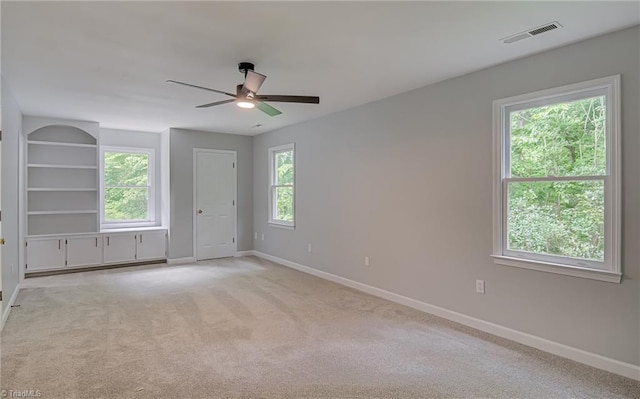 empty room featuring ceiling fan, baseboards, and light carpet