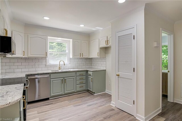 kitchen featuring a sink, dishwasher, ornamental molding, light stone countertops, and decorative backsplash