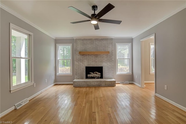 unfurnished living room with light wood-type flooring, baseboards, a fireplace, ornamental molding, and ceiling fan