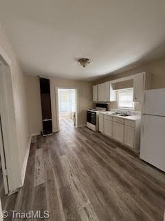 kitchen featuring white cabinets, dark hardwood / wood-style flooring, white appliances, and sink