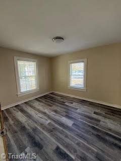 unfurnished room with dark hardwood / wood-style flooring