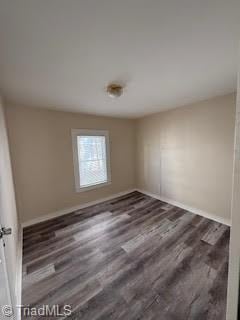 empty room with dark hardwood / wood-style flooring