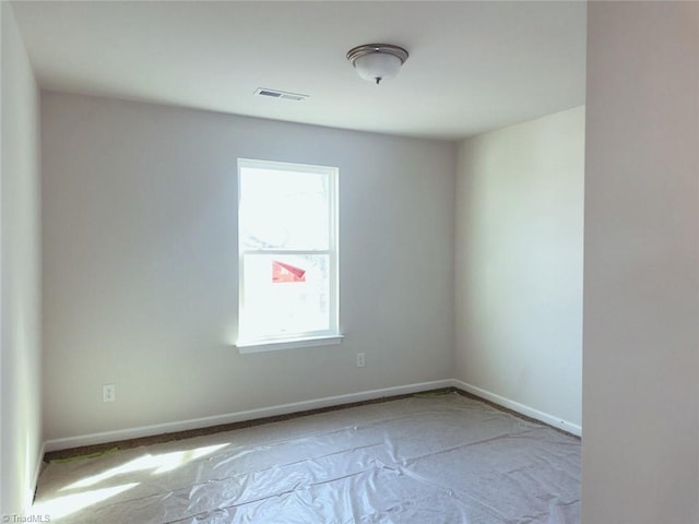 empty room with baseboards and visible vents