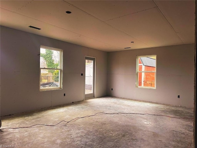 unfurnished room with concrete flooring and visible vents