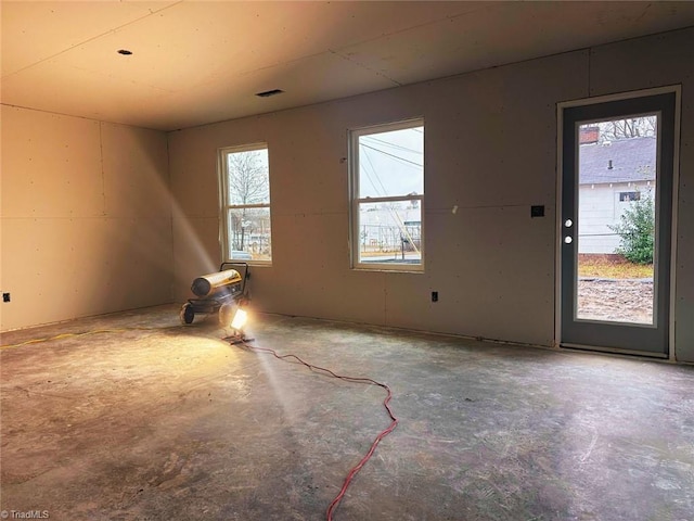 unfurnished room featuring visible vents and unfinished concrete floors