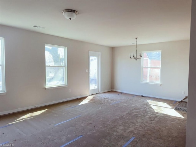 spare room featuring an inviting chandelier, visible vents, and baseboards