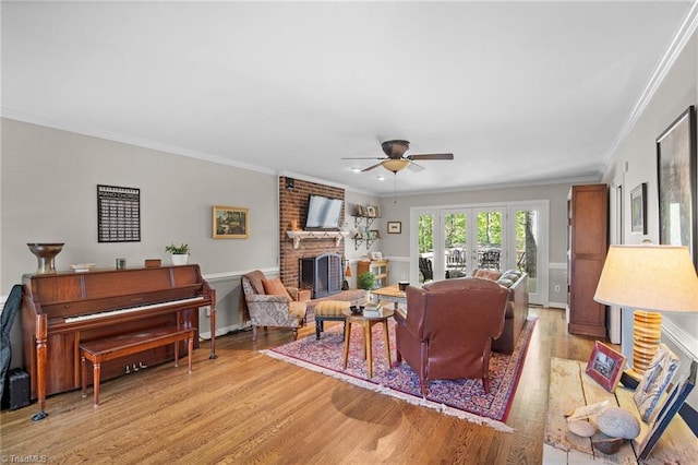 4105 Waldenbrook Rd, Greensboro, NC 27407 - living area featuring crown molding, light wood-type flooring, a brick fireplace, and a ceiling fan