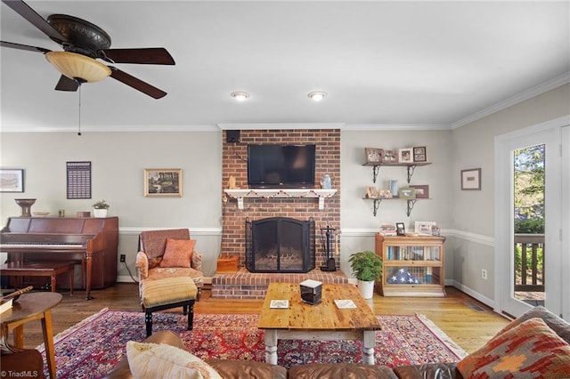 4105 Waldenbrook Rd, Greensboro, NC 27407 - living area with ceiling fan, wood finished floors, a fireplace, and ornamental molding