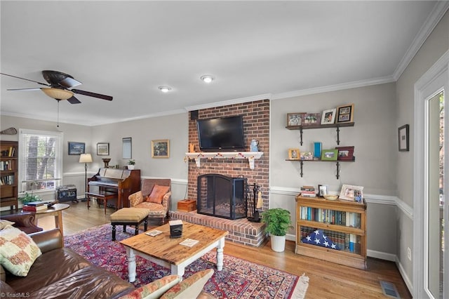 4105 Waldenbrook Rd, Greensboro, NC 27407 - living area featuring ornamental molding, a ceiling fan, a brick fireplace, and wood finished floors