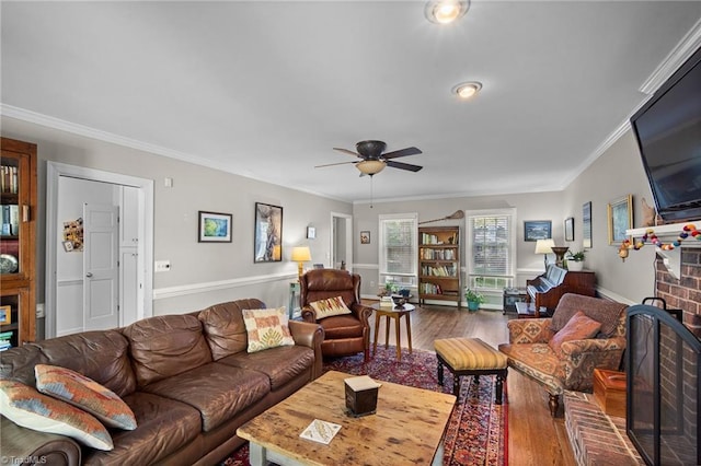 4105 Waldenbrook Rd, Greensboro, NC 27407 - living area featuring ceiling fan, ornamental molding, a brick fireplace, and wood finished floors