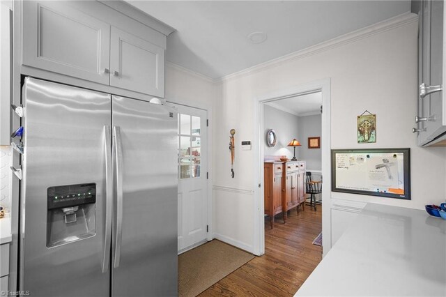 4105 Waldenbrook Rd, Greensboro, NC 27407 - kitchen featuring light countertops, dark wood-type flooring, crown molding, baseboards, and stainless steel refrigerator with ice dispenser