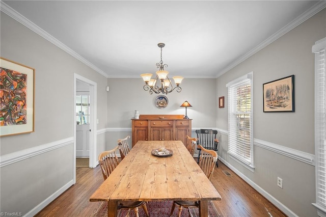 4105 Waldenbrook Rd, Greensboro, NC 27407 - dining room with baseboards, crown molding, hardwood / wood-style flooring, and an inviting chandelier