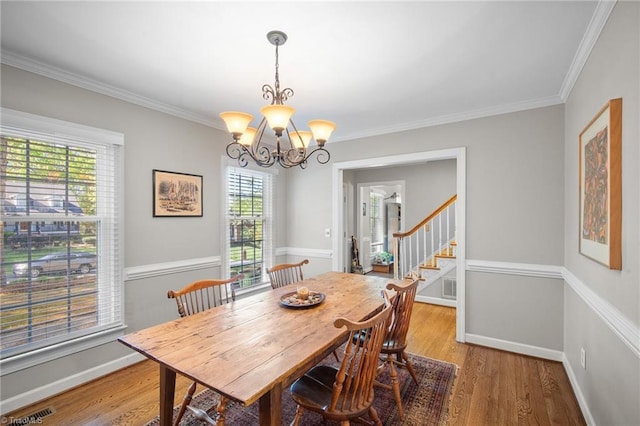 4105 Waldenbrook Rd, Greensboro, NC 27407 - dining area featuring an inviting chandelier, crown molding, stairs, and light wood finished floors