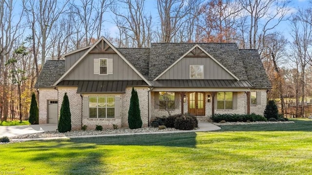 view of front of home with a front lawn, covered porch, and a garage