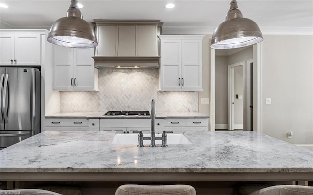 kitchen featuring premium range hood, a kitchen bar, pendant lighting, and stainless steel appliances