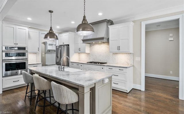 kitchen with dark hardwood / wood-style flooring, stainless steel appliances, hanging light fixtures, and premium range hood