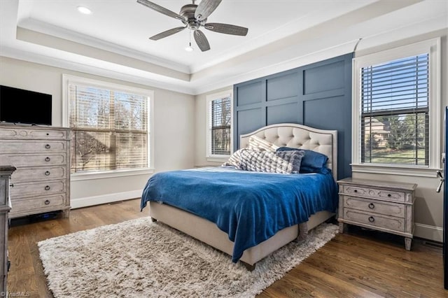 bedroom featuring a raised ceiling, ceiling fan, and dark wood-type flooring