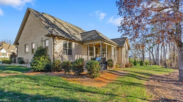 view of side of home featuring a lawn, ceiling fan, and central AC