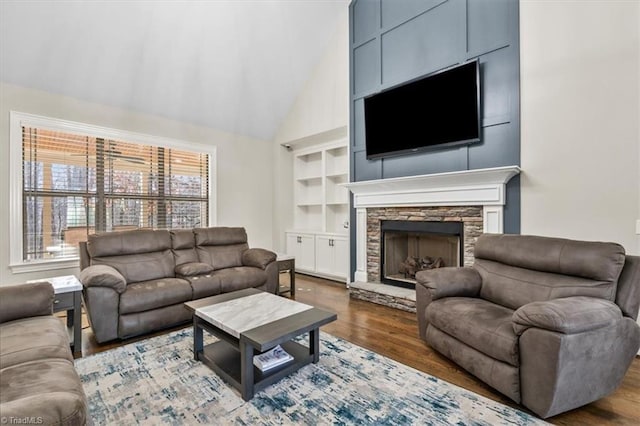 living room featuring a stone fireplace, high vaulted ceiling, and dark hardwood / wood-style floors