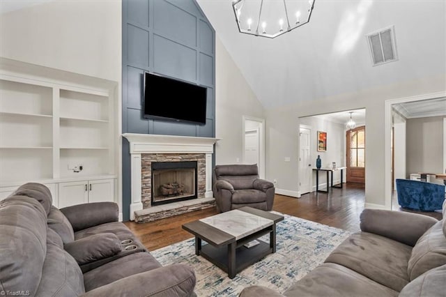 living room with a chandelier, dark hardwood / wood-style floors, high vaulted ceiling, and a fireplace