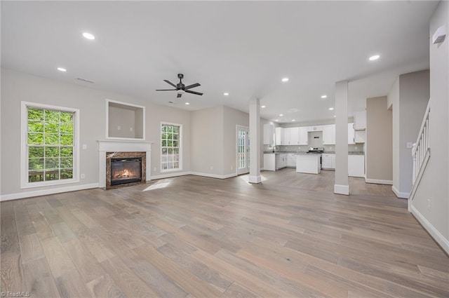 3510 Meadow Glen Ct, Clemmons, NC 27012 - unfurnished living room featuring light wood-style flooring, baseboards, a ceiling fan, and a healthy amount of sunlight