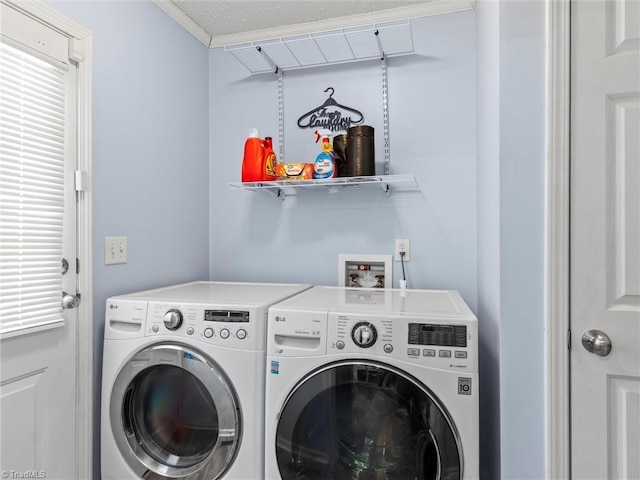 laundry area with laundry area, washing machine and dryer, and crown molding