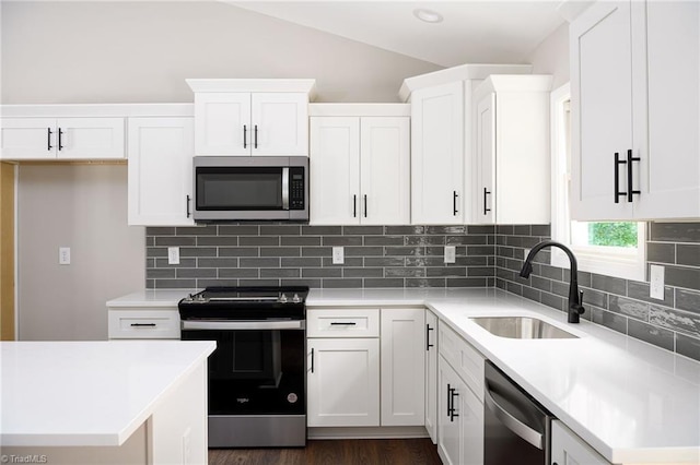 3902 NC Highway 47, Lexington, NC 27292 - kitchen featuring appliances with stainless steel finishes, white cabinets, vaulted ceiling, backsplash, and light countertops