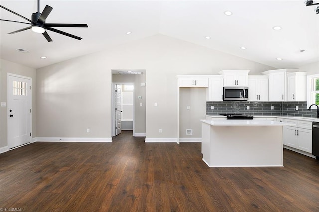 3902 NC Highway 47, Lexington, NC 27292 - kitchen featuring stainless steel microwave, vaulted ceiling, light countertops, a center island, and backsplash