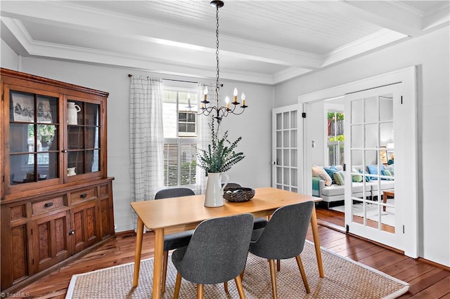 dining area featuring hardwood / wood-style floors, plenty of natural light, beam ceiling, crown molding, and a chandelier