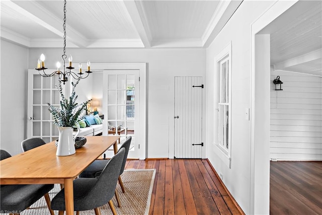 dining room with a chandelier, dark wood finished floors, beam ceiling, crown molding, and baseboards