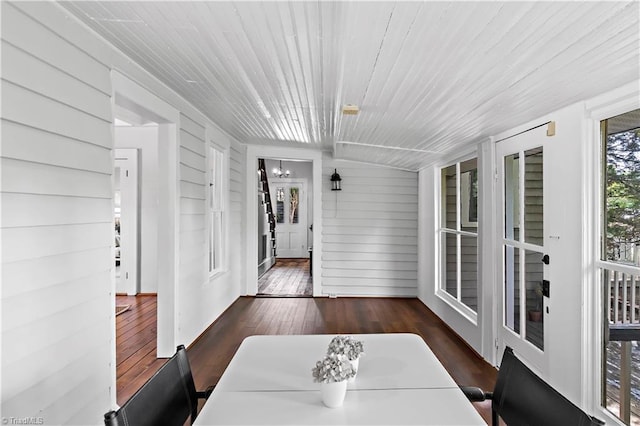 sunroom / solarium featuring a chandelier