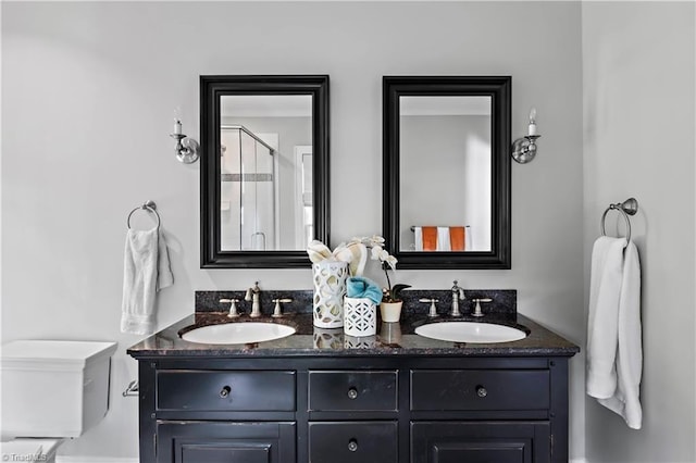 full bath with double vanity, a stall shower, and toilet