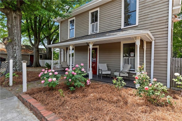view of front of house featuring covered porch and fence