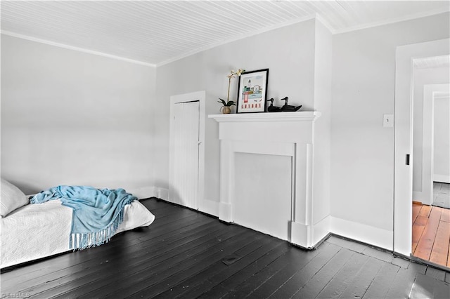 unfurnished living room with hardwood / wood-style flooring, crown molding, and baseboards