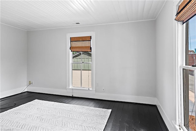 spare room featuring hardwood / wood-style floors, plenty of natural light, baseboards, and crown molding