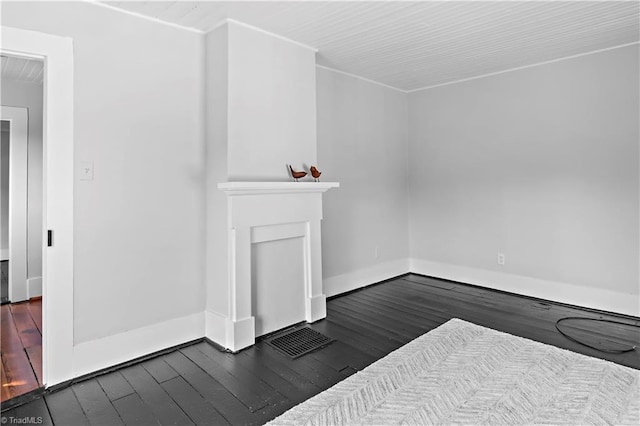 unfurnished living room featuring dark wood-style flooring and baseboards