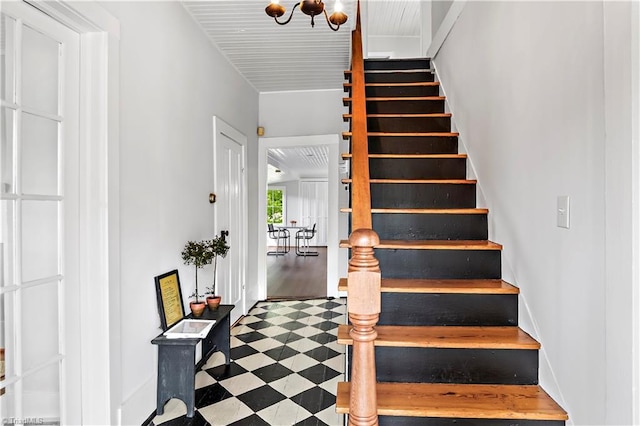 staircase with a chandelier and baseboards