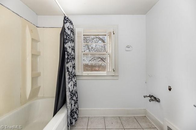 bathroom with tile patterned floors, baseboards, and shower / bath combination with curtain