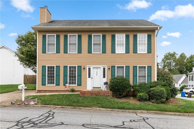 colonial home with a front lawn