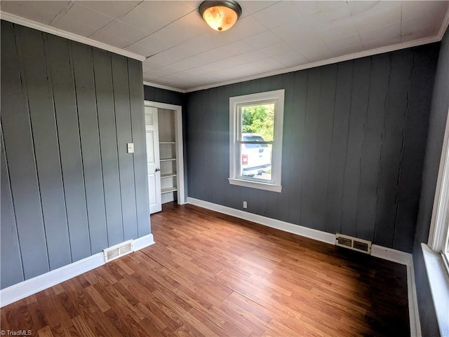 5675 Main St, Bethania, NC 27040 - empty room featuring wood finished floors, crown molding, and wooden walls