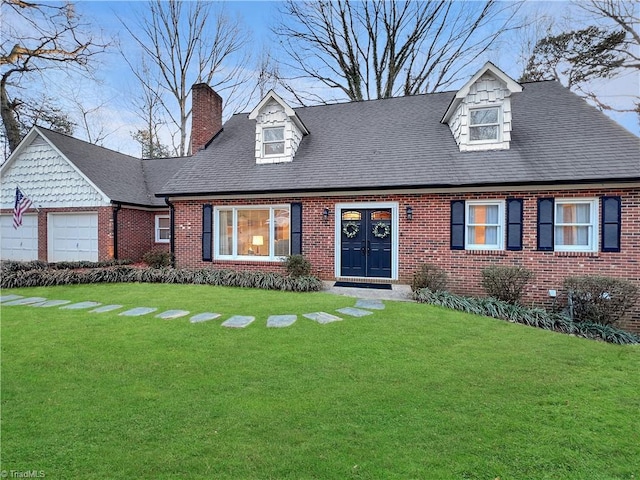 cape cod-style house featuring a garage and a front lawn