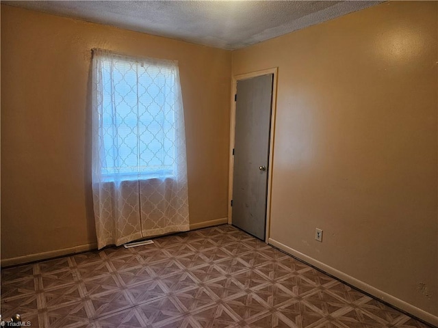 spare room with a textured ceiling