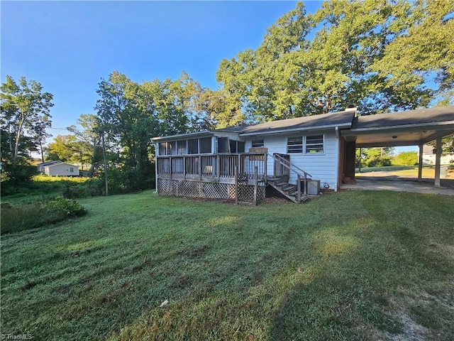 back of property featuring a yard, a carport, and a wooden deck